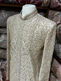 This beige white royal sherwani is brought into limelight with fine jaal embroidered coat enhanced with resham, pearl ,stone & cut dana work. The coat is styled with matching churidar pants. Size:40,42,44 Occasion: Wedding Ceremony or Reception WASH CARE INSTRUCTIONS - Please Dry clean only when it is applicable. Slight color variation is possible due to digital photography. Ready to Ship! Off White Bandhgala With Naqshi For Festive Occasions, Off White Naqshi Bandhgala For Festive Occasions, Traditional Wear In Raw Silk With Pearl Embroidery, Off White Dabka Kurta For Reception, Long Sleeve Sherwani With Resham Embroidery For Reception, Traditional Raw Silk Wear With Pearl Embroidery, Festive Off White Bandhgala With Naqshi, Traditional Pearl Embroidered Raw Silk Wear, Cream Long Sleeve Sherwani For Transitional Season