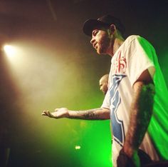 a man standing on top of a stage next to green lights