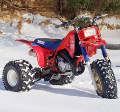 a red four wheeler parked in the snow