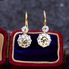 a pair of diamond earrings in a velvet box