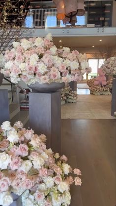 flowers are arranged in vases on display at the entrance to a building with an open floor plan