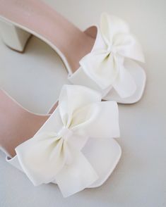 Classic satin slip on block heel sandals for casual and dressy look, adorned with a satin bow at the front that adds a romantic touch. Simple and easy wear for bridal wear, bridesmaids, holiday party, wedding parties, and any special occasions. DETAILS: HEEL HEIGHT: 2.5 InchesCOLORS AVAILABLE: Ivory and WhiteUPPER: Synthetic upper and liningMATERIALS: Manmade outsole Shoes Editorial, Off White Shop, Flower Girl Shoes, Bridal Flats, Satin Shoes, Wedding Sandals, Glitter Shoes, Wedding Parties, Proposal Gifts