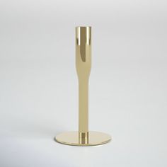 a gold plated metal object on a white surface with a circular base for the candle holder