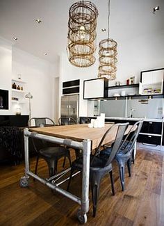 a dining room table with four chairs and a chandelier hanging from the ceiling