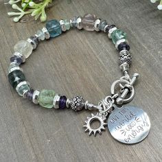 This beautiful handmade bead bracelet features stunning Rainbow Fluorite stones in both large faceted cubes and tiny saucer shapes. It is finished with  silver finish accents, a tiny sun charm, a stainless steel etched charm with the phrase "Give this world good energy", and a lovely toggle clasp. l It is strung with jewelry wire measures approximately 7 inches long. Sorry - sizing is NOT available on these toggle-style bracelets, but custom orders are welcome! Simply message me to find out more Spiritual Faceted Beads Crystal Bracelet For Jewelry Making, Fluorite Gemstone Bracelets With Round Beads, Bohemian Faceted Crystal Bracelet With Round Beads, Bohemian Silver Faceted Beaded Bracelets, Handmade Fluorite Beaded Bracelets As Gift, Fluorite Natural Stone Beaded Bracelets As Gift, Handmade Spiritual Fluorite Bracelets, Handmade Spiritual Fluorite Bracelet, Handmade Adjustable Fluorite Bracelets