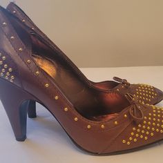 Description Miu Miu Leather Pumps* Brown Semi-Pointed Toes With Studded Accents Block Heels Authentic Pre-Loved Miu Miu Brown Leather Studded Pump. Stylish Brown Leather Pumps With Gold Style. Imported. Made In Italy. Features Gold Time Studs. Size 8 Does Not Include Boxdust Bag. Used, In Good Condition. Heels: 4" Details:Moderate Scuffs At Soles; Minor Scuffs At Heel Cap And Toe Box; Minor Blemish At Heel; Light Creasing At Exterior; Minor Residue At Insoles. Used, In Good Condition. Please Zoo Spring High Heels With Gold Studs, Brown Leather Evening Court Shoes, Leather Heels With Studded Rubber Outsoles For Evening, Brown Court Shoes With 4-inch Heel For Party, Gold Studs Pointed Toe Heels, Miu Miu Designer Pointed Toe Heels, Studded Leather Heels With Closed Toe, Miu Miu Closed Toe Heels For Formal Occasions, Studded Leather Open Toe Heels