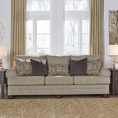 a living room scene with focus on the couch and pillows in front of the window