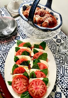 there is a platter with tomatoes and other food on the table next to it