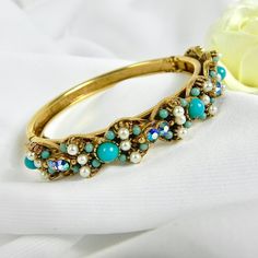 This stunning vintage Florenza bracelet is in excellent condition. NO missing beads, stones or crystals.  The latch opens and closes easily and has an added chain for added security. It is in a gold tone metal and accented with turquoise and cream coloured pearls. The underside of the bracelet has engraved flowers and leaves that decorate the band. This wonderful piece of vintage jewellery is elegant and fun at the same time. Would look great with any dressy outfit but also goes great with jeans Vintage Beaded Bangle Bracelet, Vintage Beaded Bangle Bracelets, Vintage Turquoise Beaded Bracelets, Vintage Jeweled Bracelets For Wedding, Vintage Jeweled Bangle For Wedding, Vintage Crystal Bangle Bracelet Gift, Vintage Crystal Bracelet With Jewels As A Gift, Vintage Jeweled Crystal Bracelet Gift, Vintage Jeweled Crystal Bracelet For Gift