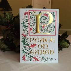 a card with the letter d on it sitting on a table next to christmas decorations