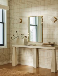 a white table with a mirror and vase on it