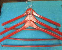 four red hangers on a blue cloth