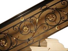 an ornate iron railing with gold flowers on it