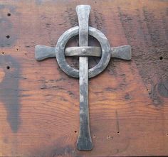 an old metal cross on top of a wooden table