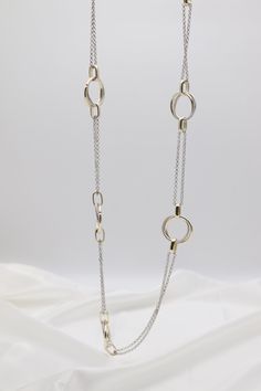 This Gold & Silver Cable Floating Dig Circle Double Belcher Necklace is expertly crafted and designed to elevate any look. Made from high-quality gold and silver, this necklace features a unique floating dig circle design and a double belcher chain for a modern and luxurious touch. A must-have for any jewelry collection. Length: 36 inches Circle: 1.13” Width Closure: Lobster Claw Material: Brass with 18K Gold Plating and Rhodium Coating Lead Free and Hypoallergenic Modern Sterling Silver Double Chain Jewelry, Gold Necklaces With Delicate Open Circle Chain, Delicate Round Metal Chain Necklace, Delicate Metal Chain Necklace, Silver Circle Necklace For Formal Occasions, Elegant Silver Circle Necklace, Formal Silver Circle Necklace, Gold Jewelry With Adjustable Chain And Open Circle Design, Modern Sterling Silver Necklaces With Double Chain