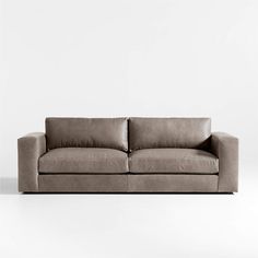 a gray couch sitting on top of a white floor