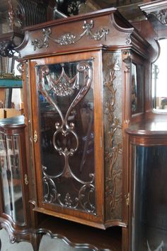 an ornate wooden cabinet with glass doors