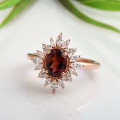 a close up of a ring with a red stone in the center and white diamonds around it