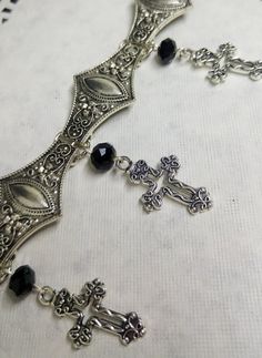 Victorian Gothic metal choker with hollow crosses and black crystal beads, ornate metal necklace, Victorian jewelry, Gothic jewelry A beautifully ornate gothic silver metal choker with Victorian hollow cross charms and black faceted crystal beads. It measures approx. 11 inches in length and has lobster clasp fastening and an extension chain, so that it can be adjusted to fit the neck. The choker is made up of 7 silver toned metal ancient style sections that have intricate detailing. A marvelous Gothic Metal Necklace With Intricate Design, Gothic Metal Jewelry With Filigree, Gothic Filigree Metal Jewelry, Gothic Silver Metal Body Jewelry, Silver Gothic Metal Body Jewelry, Gothic Silver Necklaces For Festival, Silver Gothic Body Jewelry, Gothic Metal Choker For Festivals, Gothic Silver Jewelry For Festival