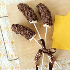 chocolate cookies and marshmallows are on a stick with a bow tied around it