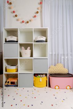 a child's room with toy cars, toys and bookshelves on the floor