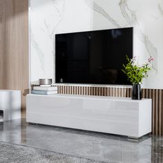 a white entertainment center with a flat screen tv mounted on it's side wall