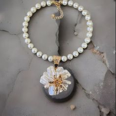 Length: 18.5" Round Glass Pearl Baroque Flower Shape Pendant Gold Tone Accents Large Gold-Tone Hook And Loop Clasp Lobster Claw Clasp With A 3" Chain Extender White Flower Charm Necklace, White Flower-shaped Necklace With Pearl Pendant, White Flower-shaped Pearl Pendant Necklace, White Flower Pendant Necklace For Parties, White Pearl Necklace With Flower Pendant, White Flower-shaped Pearl Necklace With Pendant, White Flower-shaped Pearl Chain Necklaces, White Flower Shaped Pearl Chain Necklace, White Flower-shaped Necklace With Pearl Charm