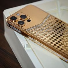 a gold cell phone sitting on top of a white box