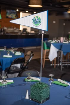 the table is set up with blue linens and green napkins for an event