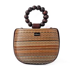 Introducing our new brown and tan Maria bag. This stunning bag offers a unique statement look with elevated luxury vacation moments in mind. You'll be sure to get admiring glances with this beautiful bag on your arm.  Crafted by artisans in the Philippines, this bag is created using woven Buntal straw - a natural and organic fiber from large leaves of abundant palm trees that are grown sustainably in the Philippines. Each piece of fiber is then meticulously handwoven to create a unique and natural textile that respects its origin.  The bag is complete with beaded top handles and  also comes with a detachable crossbody strap - perfect for when you need a hands free option. Made from Buntal weave and wooden beads Detachable crossbody strap Clean with a damp cloth Luxury Bags With Bamboo Handle For On-the-go, Natural Color Bags With Bamboo Handle For On-the-go, Natural Bags With Bamboo Handle For On-the-go, Chic Brown Straw Bag With Removable Pouch, Luxury Brown Bags With Bamboo Handle, Luxury Brown Bag With Bamboo Handle, Brown Satchel With Round Handle For On-the-go, Luxury Brown Shoulder Bag With Round Handle, Brown Straw Shoulder Bag For On-the-go