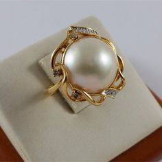 Beautiful 18K Karat 750 Yellow Gold Mabe Pearl & Diamond Ring  Condition : Pre-Owned Professionally Polished to look New Total Weight : 8.7 Grams Gold Color : Yellow Gold Pearl Size : 14.20mm Total of 10 Round Cut Diamonds  (Please See Pictures for more detail on the Sizes; they are by Millimeter) What you see in the pictures is what you will receive. Pearl Diamond Ring, Gold Pearl Ring, Pearl Rings, Pearl And Diamond Ring, Mabe Pearl, Fancy Earrings, Rose Gold Band, Jewelry Beautiful, Pawn Shop