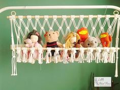 several stuffed animals are hanging in a hammock with tassels on it