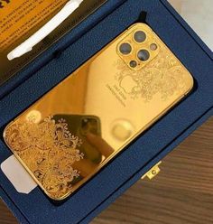 an open box with a gold phone in it