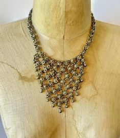 This vintage treasure is created from softly aged silver tone metal.  It has an ornate pattern and is a bib style. It is done in a Middle Eastern chain mail style.  Ornate links are dimensional and form a bib.  Little ball dangles hang down for more movement.  This is a nice weight of metal.  Great, unique statement piece! Measurements: 17" long inside neckline; 4" wide in front Condition:  Very good vintage condition, vintage patina Please view enlarged photos for details.  Much more beautiful in real life! I am not an expert on vintage jewelry, but I do buy and sell what I love! Since these items are vintage, they may have a wonderful aged patina and are not meant or expected to look brand new. I treasure their imperfections as part of their charm and history.  My Shop: http://www.etsy.c Ornate Pattern, Chainmail Necklace, Bib Necklaces, Chain Mail, Necklace Vintage, Bib Necklace, Mixed Metals, Middle Eastern, Necklace Silver