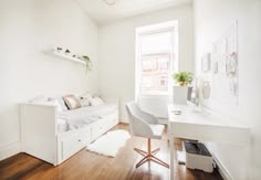 a white room with a bed, desk and chair next to a window in the corner