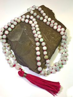 108 beaded natural Jadeite Mala Necklace  Gems: 506ct Jadeite 8mm plain round gemstones and 10.3 Rose Quartz Guru bead Length 24" inches  A Mala Necklace Mala Beads are more than just pretty necklaces. Each element of a Mala Necklace carries a meaning. Learn more about each part of a Mala Necklace and how it can help you on your own journey of meditation and intention setting. 108 Beads Malas always have 108 Beads. According to traditional Buddhism, 108 represents the number of mortal desires of Spiritual Jade Jewelry With 108 Beads, Beaded Jade Necklaces With Gemstone Beads, Jade Beaded Necklace With Gemstone Beads, Jade Beaded Necklaces With Gemstone Beads, Spiritual Hand-strung Jade Beaded Necklace, Jade Bead Necklaces For Meditation, Spiritual Single Strand Jade Beaded Necklace, White Jade Beaded Necklaces With Round Beads, Gemstone Beads Mala As Gift