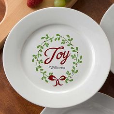 two white plates sitting on top of a wooden table next to fruit and utensils