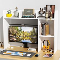 a desk with a computer monitor and headphones on it