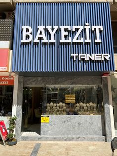 a store front with blue corrugated on the side and white lettering that reads bayezt