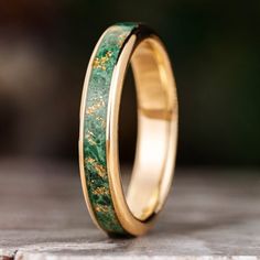 a wedding ring with gold and green marble inlay