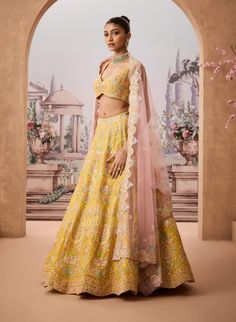 Step into refined elegance with this vibrant yellow lehenga adorned with intricate floral baroque patterns. Embellished with resham, gotapatti, and shimmering sequins, each detail reflects timeless craftsmanship. Paired with a striking pink dupatta, this ensemble offers a harmonious blend of tradition and modern charm, perfect for the sophisticated woman. Semi-stitched Yellow Palazzo Set With Floral Embroidery, Yellow Floral Embroidered Palazzo Set For Festivals, Yellow Palazzo Set With Intricate Embroidery For Diwali, Yellow Palazzo Set With Sheer Dupatta For Wedding, Yellow Embroidered Palazzo Set For Diwali, Yellow Palazzo Set With Dupatta For Reception, Yellow Palazzo Set For Reception And Navratri, Yellow Palazzo Set With Zari Work For Reception, Yellow Gota Work Sets For Reception