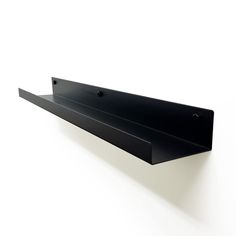 a black shelf mounted to the side of a wall