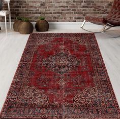 a large red rug in front of a brick wall