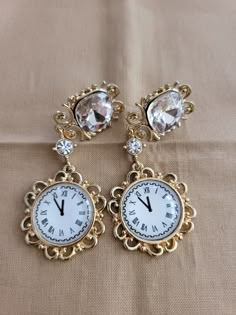 "The earrings have a 7 carat created clear square zircon stone with a 3mm round zircon accents and an \"almost midnight\" time on a clock design.  (not a time piece) 18K gold plated." Timeless Silver Earrings For Party, Diamond Jeweled Earrings For Anniversary, Timeless Gold Diamond Earrings, Elegant Jeweled Clip-on Earrings For Formal Occasions, Elegant Jeweled Clip-on Earrings For Formal Events, Luxury Jeweled Silver Earrings, Gold Jeweled Cubic Zirconia Earrings, Luxury Crystal Earrings, Elegant Jeweled Metal Clip-on Earrings