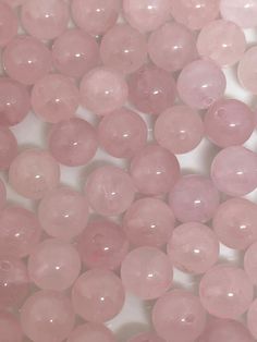 pink beads are scattered on a white surface