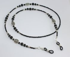 Beautiful black beaded glasses chain.  Made using tiny black glass beads and black glass pearls and crystals with focal Celtic swirl design beads.  The glasses chain is finished with rubber ends to securely attach your glasses.  Please choose desired length from the drop-down menu. Presented in an organza pouch.  Lovely and useful gift idea. Black Glass Beaded Jewelry, Black Glass Beaded Necklaces With Round Beads, Black Beaded Glass Necklaces, Black Beaded Glass Necklace, Black Glass Beaded Necklace With Round Beads, Handmade Glass Beads In Black, Handmade Black Glass Beads, Black Glass Beaded Necklaces With Beaded Chain, Black Glass Beaded Necklace With Beaded Chain