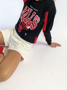 Our absolute favorite Chicago Bulls sweatshirt! Features the classic Chicago Bulls red coloring in the ribbed neckline and inner sleeves. The middle front of the sweatshirt showcases a beautiful print with the Chicago Bulls Logo. The perfect piece to pair with the AGOLDE 90's Pinch Waist Jean. 50% polyester 50% cotton Tag reads Official Licensed Product NBA - Made in USA Recommended for size xs-s, depending on the desired fit. Modeled on a small frame. Please refer to the measurements listed bel Chicago Bulls Sweatshirt, Chicago Bulls Logo, Bulls Logo, Vintage Chicago Bulls, Bull Logo, Knit Outerwear, Tunic Sweatshirt, Tank Top Camisole, Silk Charmeuse