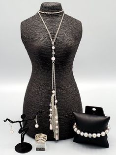 This sophisticated white and silver custom set comes with a necklace and complimentary earrings, a stretchy bracelet and and a ring with a stretchy back.Necklace - "Timeless Tassels": Dainty silver pearls and sparkling white crystal-like beads gives way to two shimmery silver chain tassels. Infused with ornate silver beads, strands of matching beads trickle down the tassels for a refined flair. Features an adjustable clasp closure. Includes one pair of matching earrings. Bracelet - "Really Respl Silver Metal Pearl Necklace For Party, White Metal Jewelry With Silver Beads, Silver Pearl Chain Jewelry For Party, Silver Pearl Jewelry For Party, Party Silver Jewelry With Pearl Chain, Adjustable Silver Beaded Pearl Necklace, Silver Beaded Pearl Necklace For Parties, White Pearl Jewelry With Silver Beads, Adjustable Silver Beads Jewelry For Party