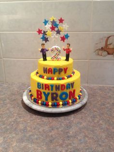 a yellow birthday cake sitting on top of a counter