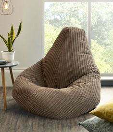 a bean bag chair sitting on top of a hard wood floor next to a window